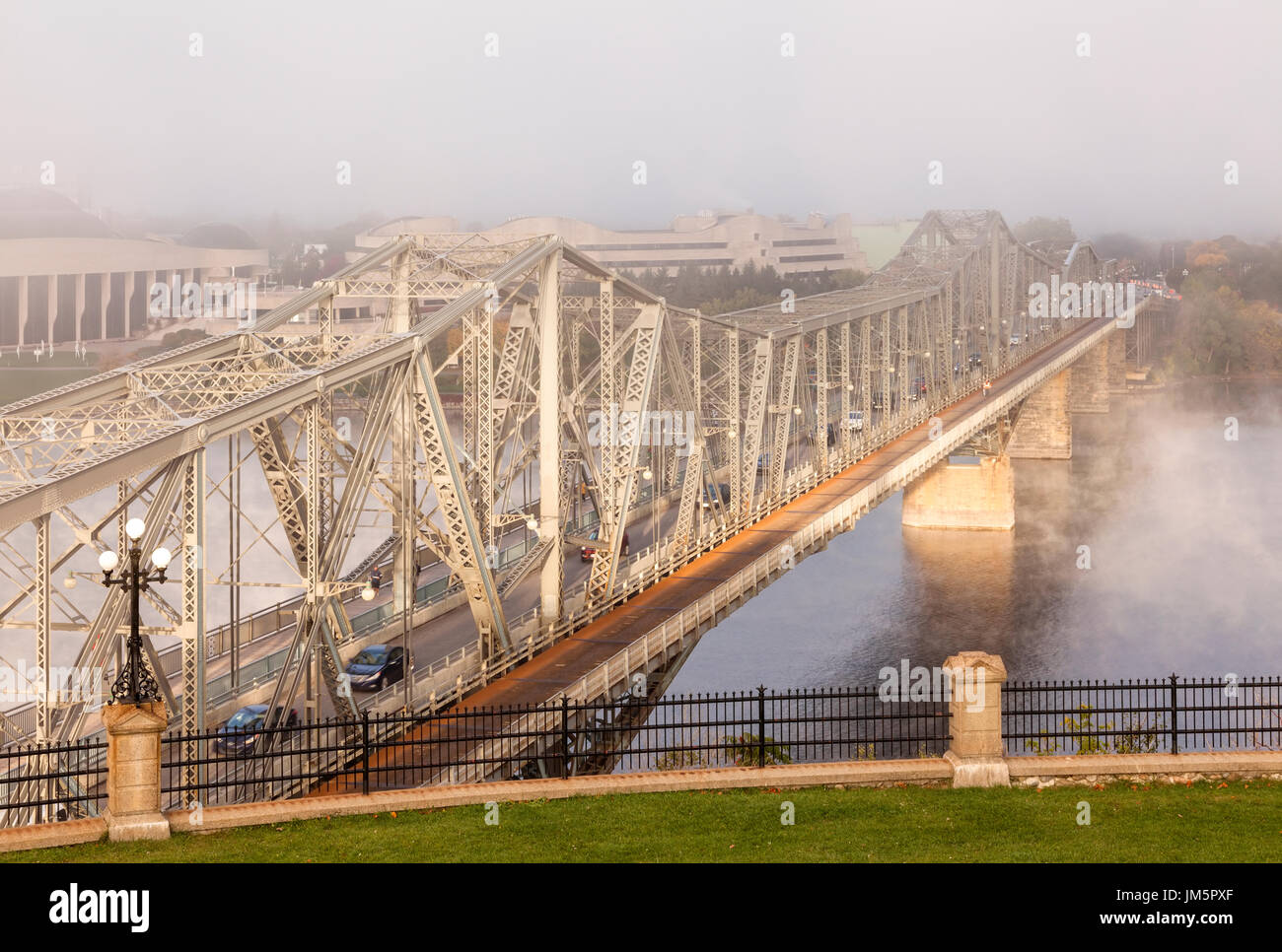The Royal Alexandra Interprovincial Bridge is a steel truss cantilever bridge that spans the Ottawa River during a foggy morning in Ottawa, Ontario. Stock Photo
