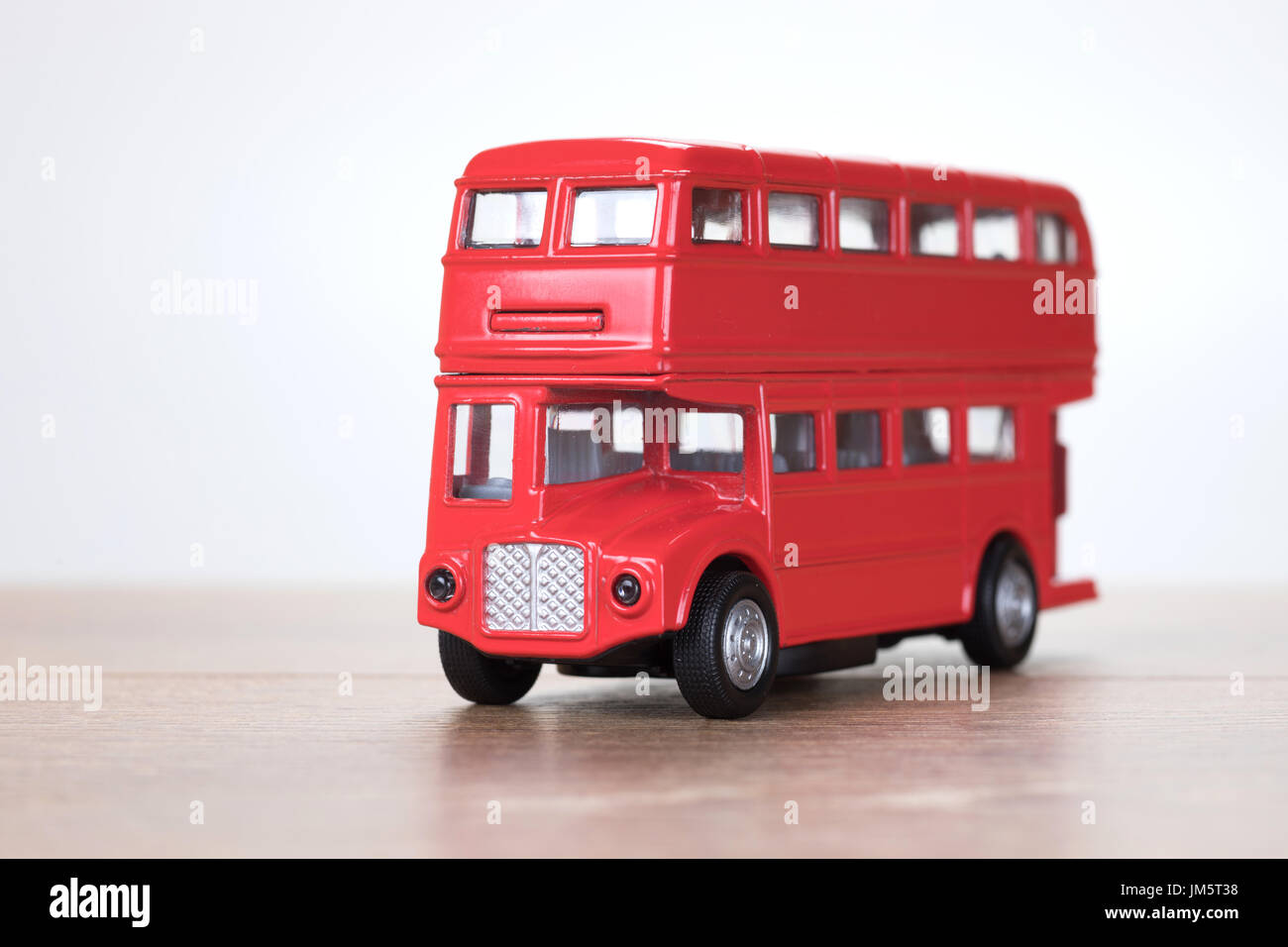 Close up view of a small scale model red London double decker bus toy on a  wooden table with copy space to the side Stock Photo - Alamy