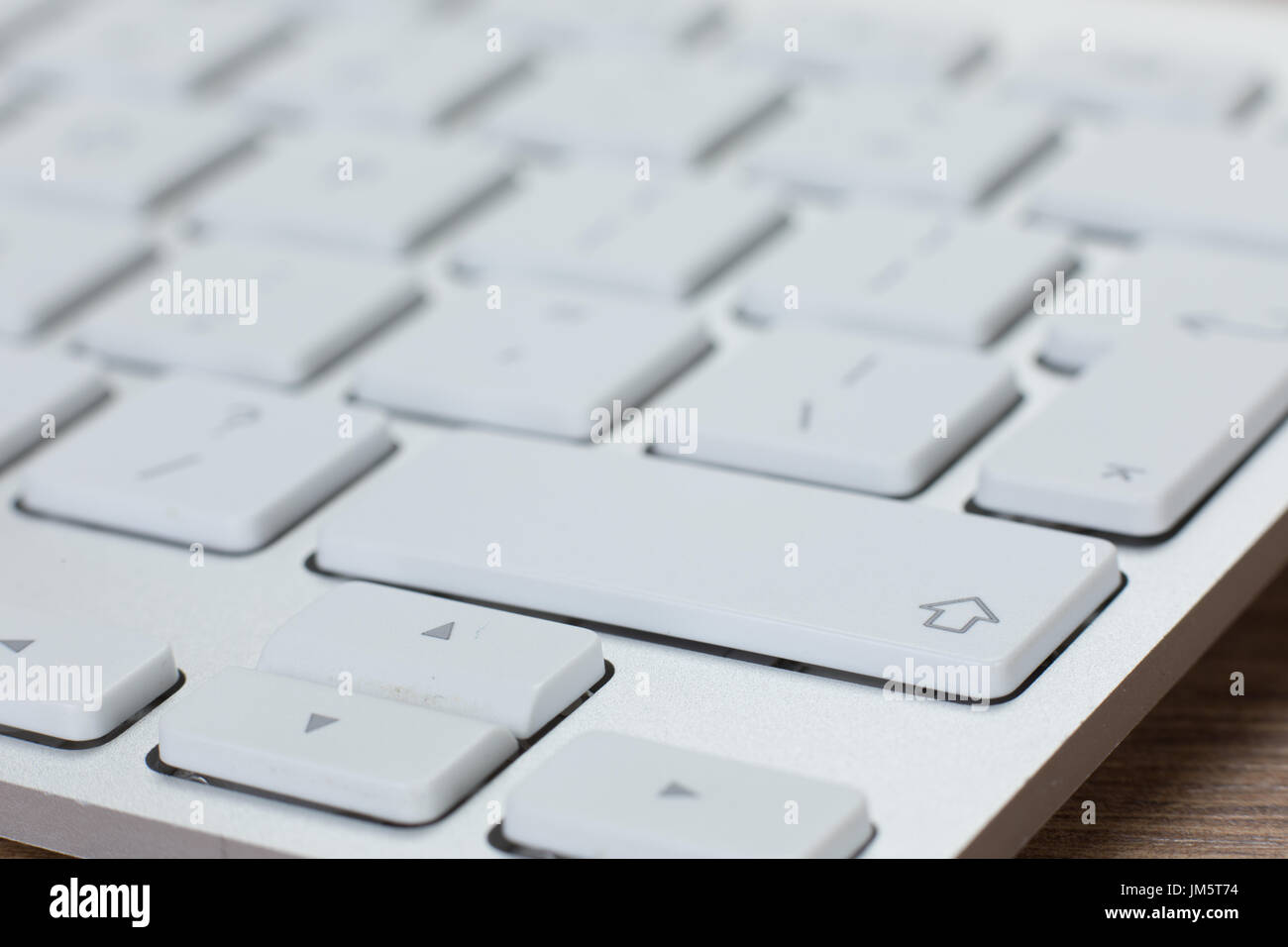 Close-up isometric view on shift and arrow keys of selective focus or partially obscured white and silver keyboard Stock Photo