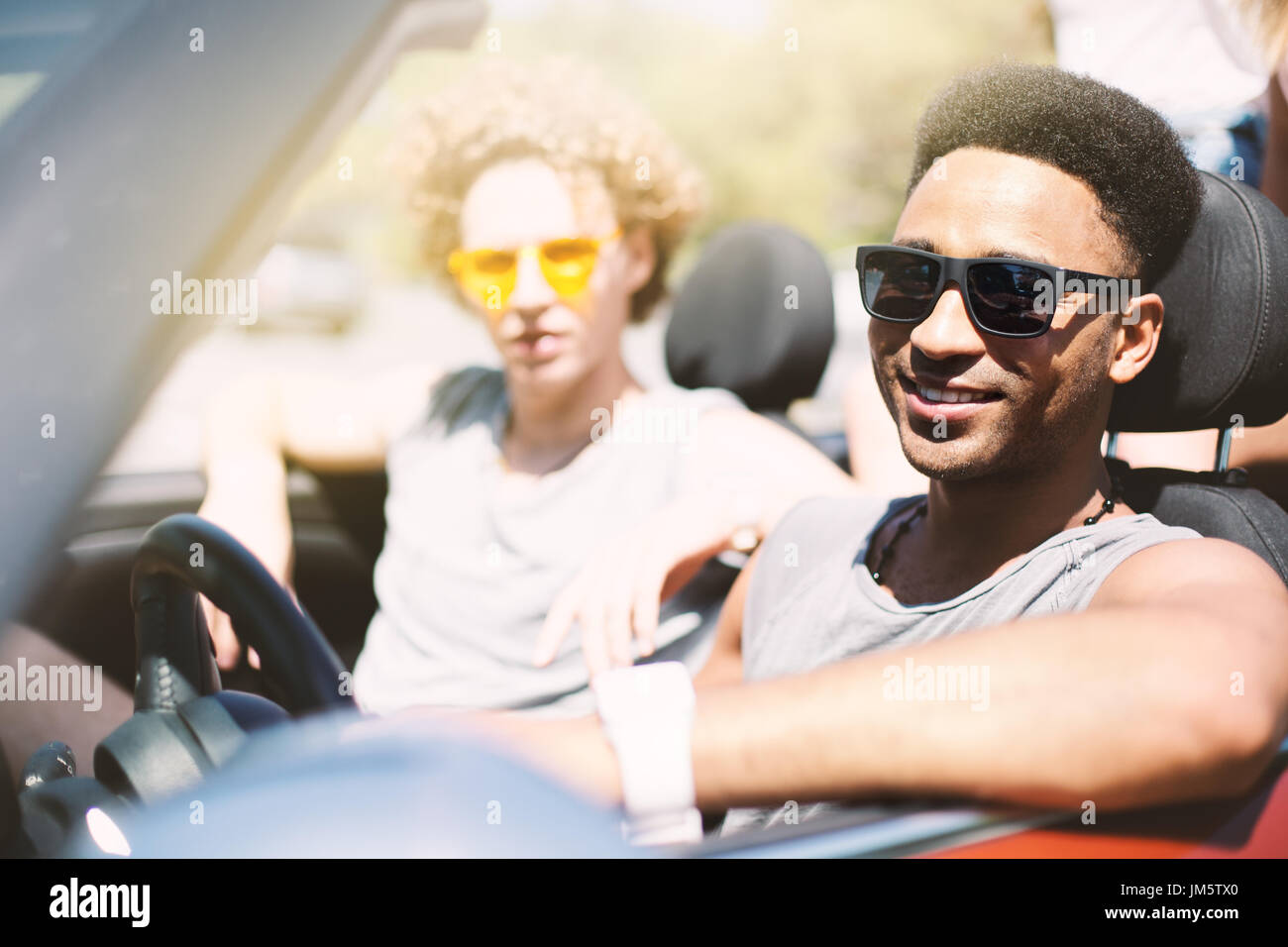 Young friends in cabriolet car ready to vacation Stock Photo