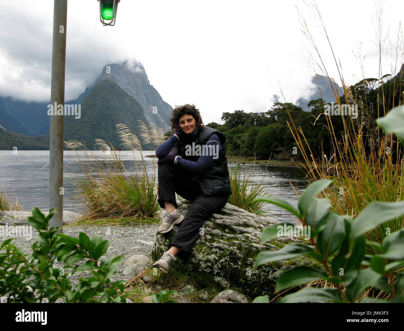 Lady in picturesque setting at Milford Sound Stock Photo
