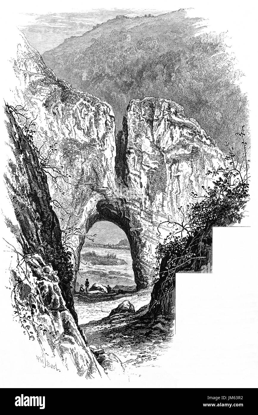 1870: Walkers in Reynard's Cave in  Dovedale, a valley in the Peak District, Derbyshire, England Stock Photo