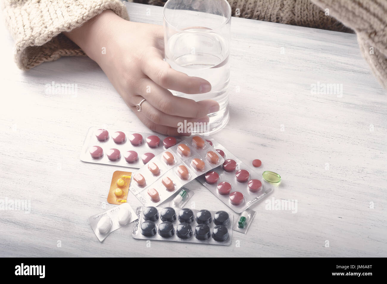 Close-up of woman hands with glass of water, pills and tablets. Healthcare concept. Stock Photo