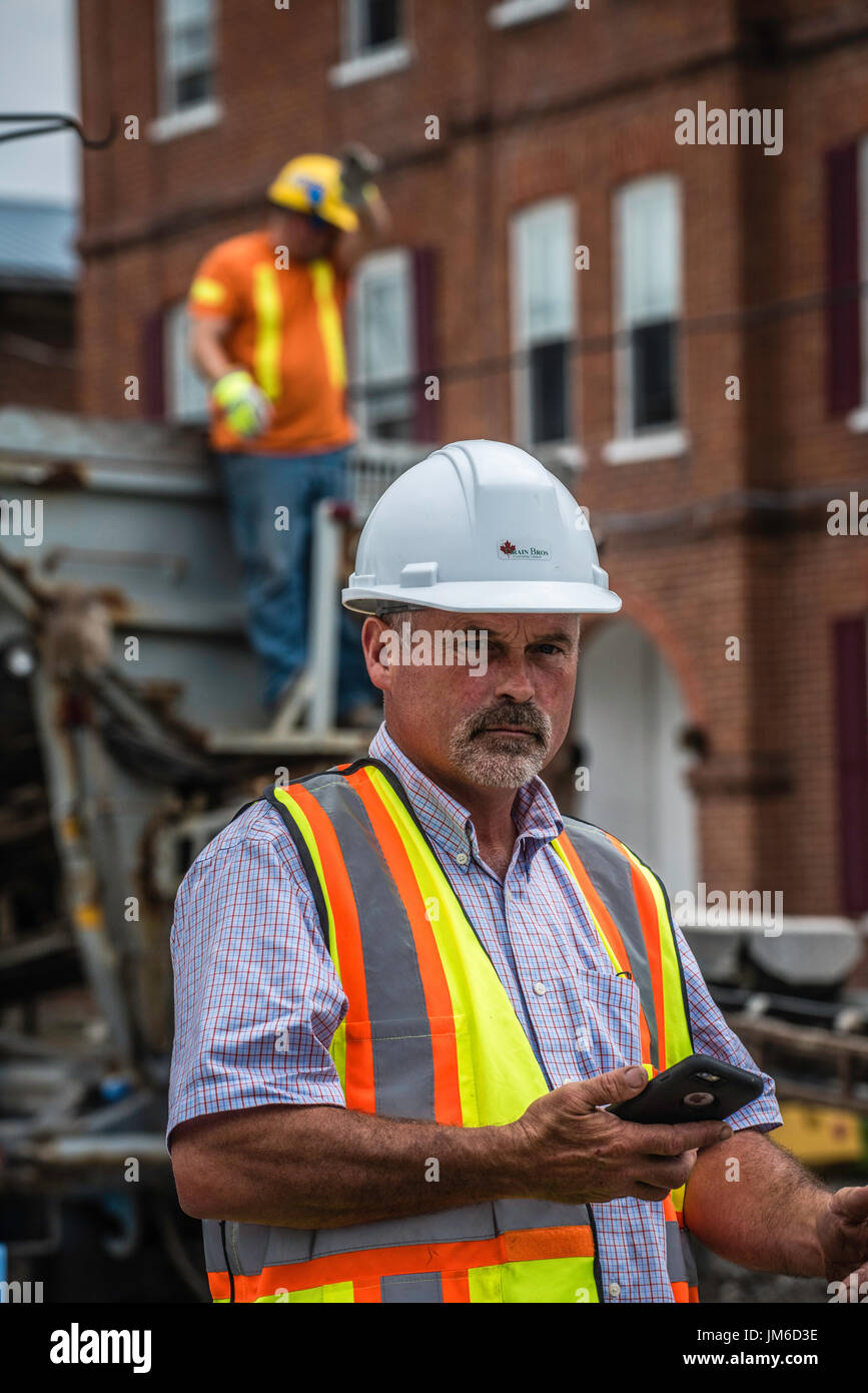 Canadian industrial construction workers laying paving on streets in ...