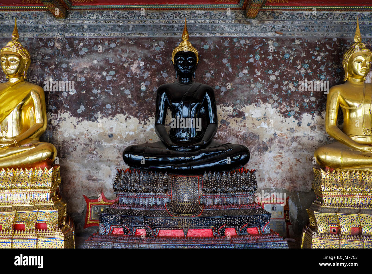 Sitting black Buddha statue in outer corridor of Wat Suthat Thepwararam