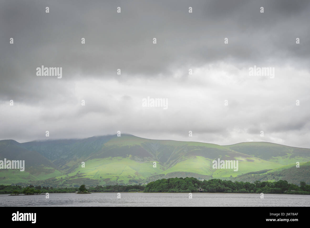 View the UK Lakeside District of the Northern Highland tourist destination. The lake is surrounded by hilly mountains and local small town and village Stock Photo