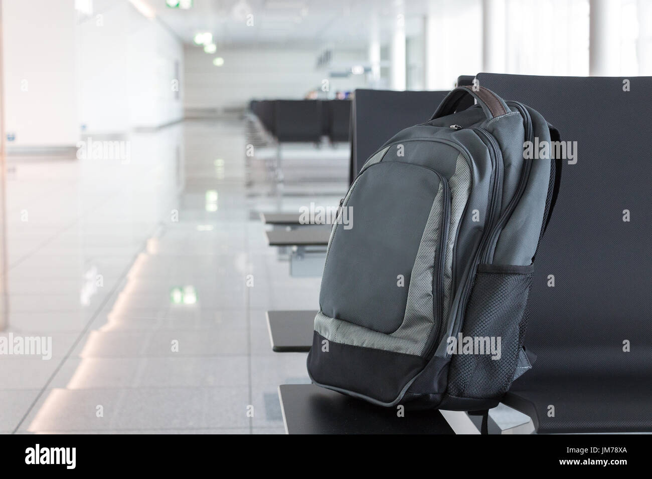 Abandoned, unattended cabin backpack on chair at the gates area of an airport. Stock Photo