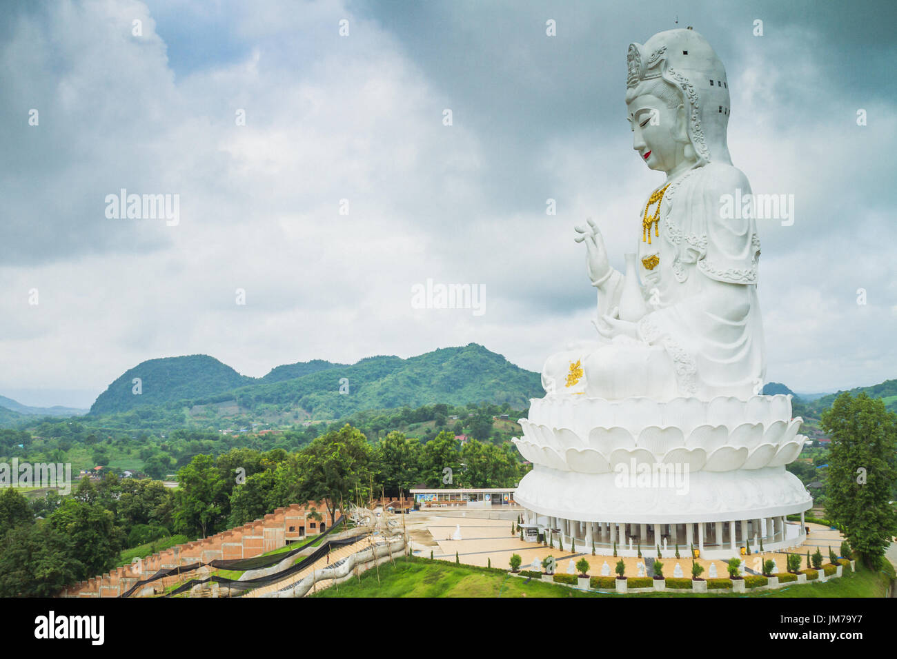 Chiang Rai, Thailand - July 12, 2017: White Guanyin Statue The Goddess Of Compassion (In Chinese Buddhism) Inside Wat Huai Pla Kang At Rain Clouds Bac Stock Photo