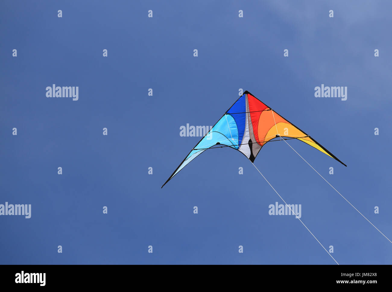 Colorful kite in blue sky. Kite on summer sky background close-up. Stock Photo