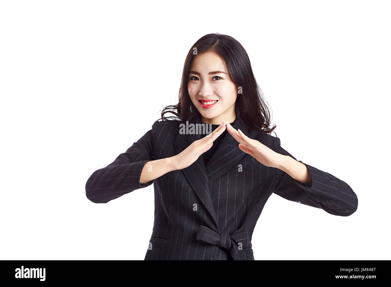 young asian real estate agent showing a roof sign, studio shot, isolated on white background. Stock Photo