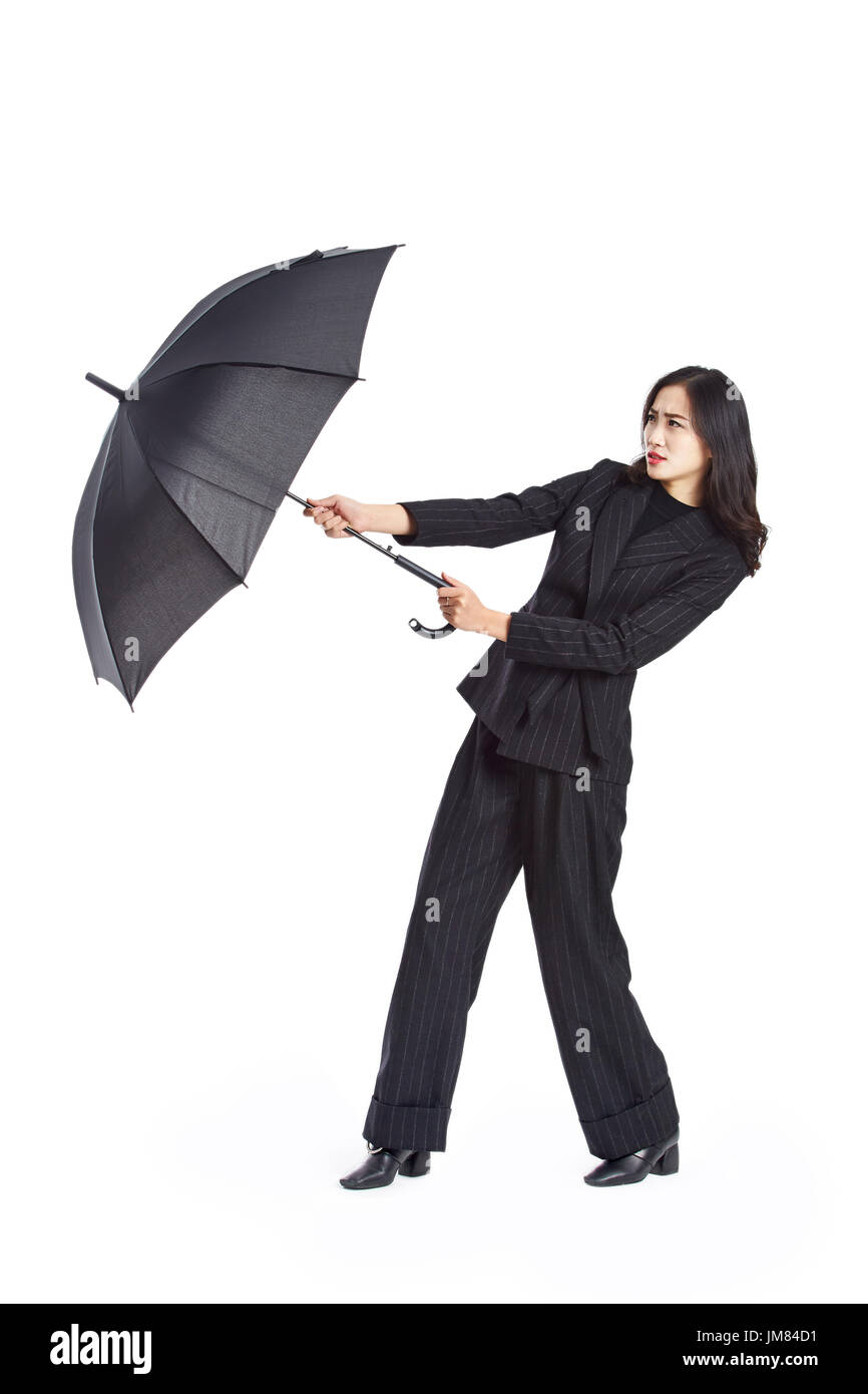 young asian businesswoman holding a black umbrella, studio shot, isolated on white background. Stock Photo