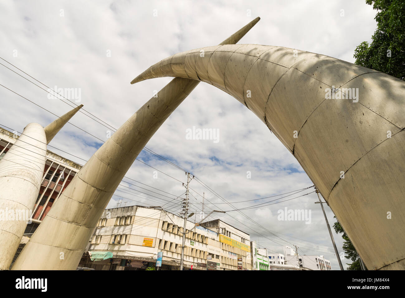 Aluminium Elephant Tusks Above Moi Avenue In Mombasa With Local Buildings In Background, Kenya Stock Photo