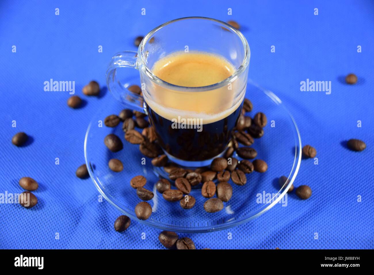 Espresso in a glass cup with coffee beans Stock Photo