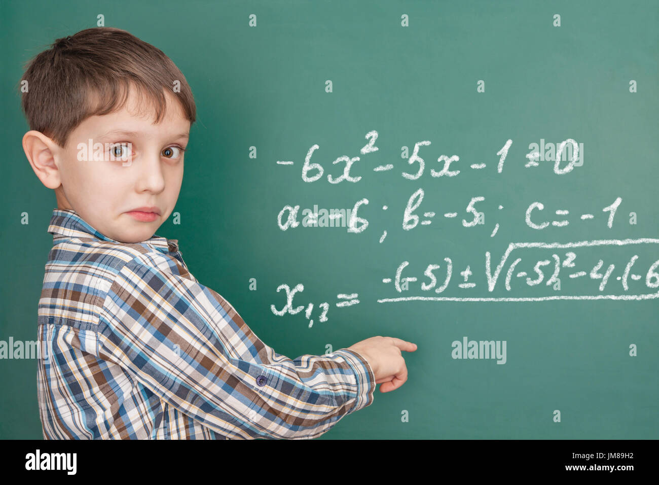 Lagging learner at the blackboard looking for a hint Stock Photo