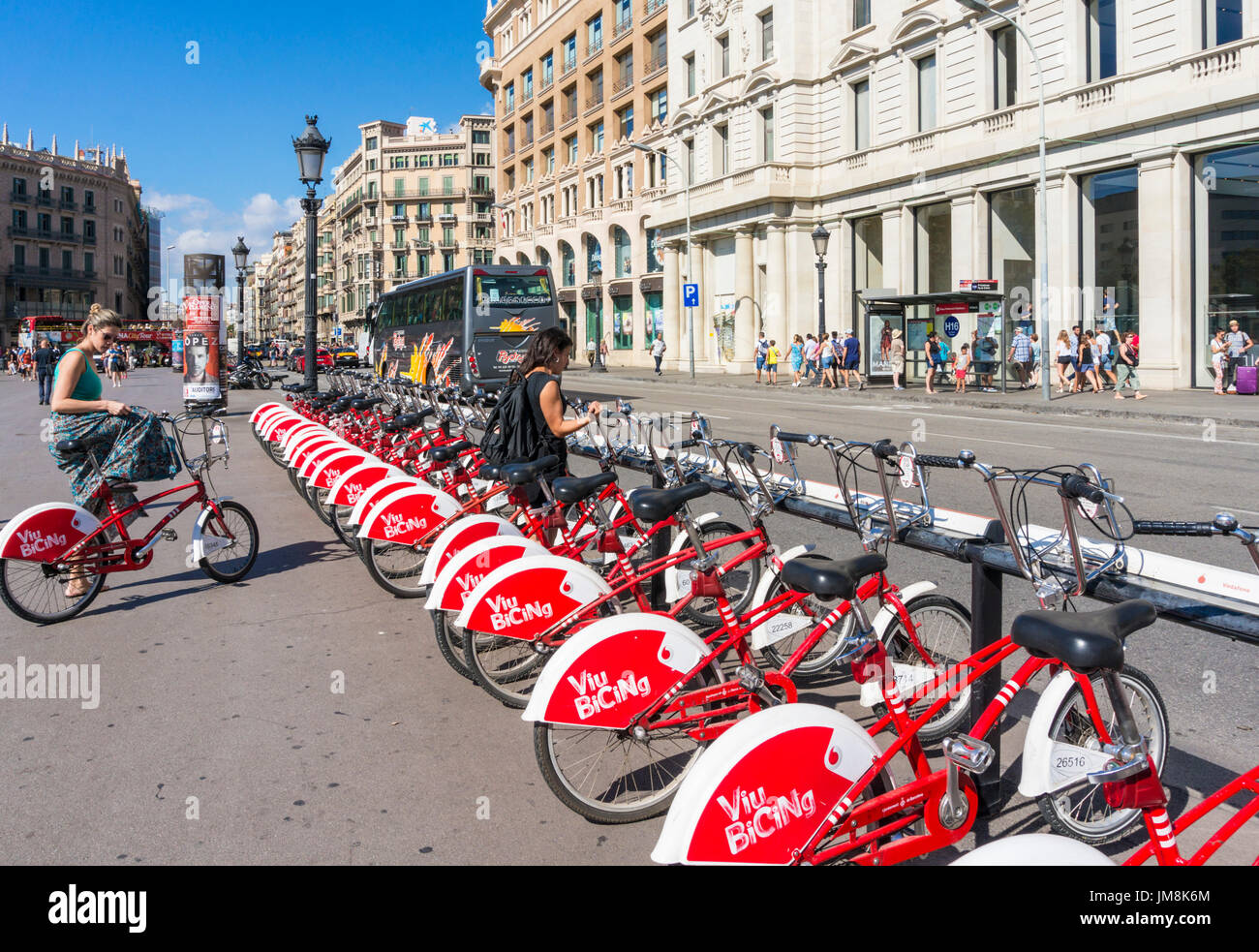 Barcelona Catalunya barcelona Plaça de Catalunya bikes hire woman on bike central square of Barcelona eu europe Catalonia Stock Photo - Alamy