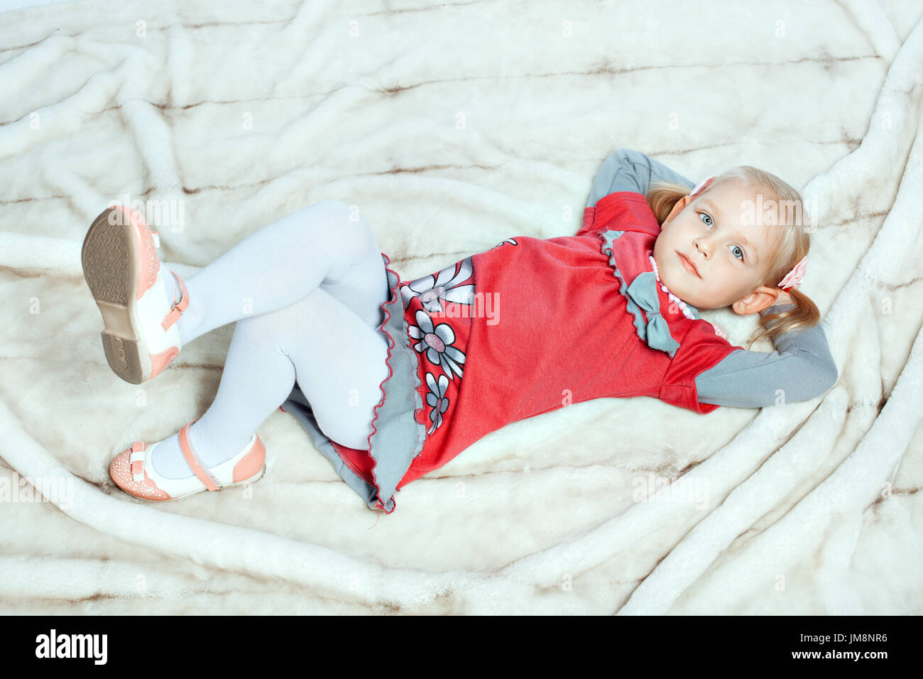 Baby girl is lying with her legs crossed Stock Photo Alamy