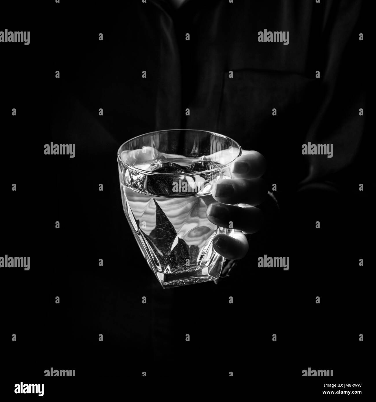 Black Mania. female hand isolated on black showing glass of water Stock Photo