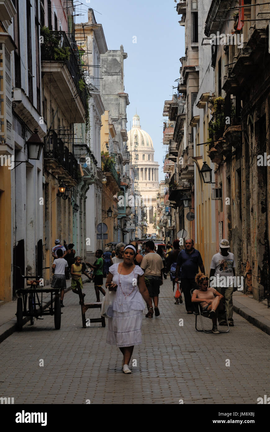 City life in Habana vieja, the old city center of Havana. In the background hints El Capitolio, the seat of the old Cuban parliament. Stock Photo