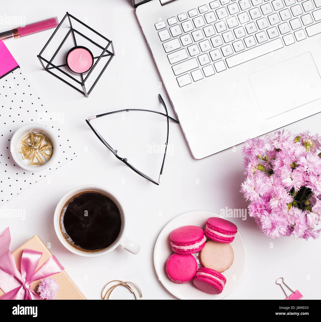 Woman's workplace concept. Coffee, laptop and different small objects on white. Stock Photo