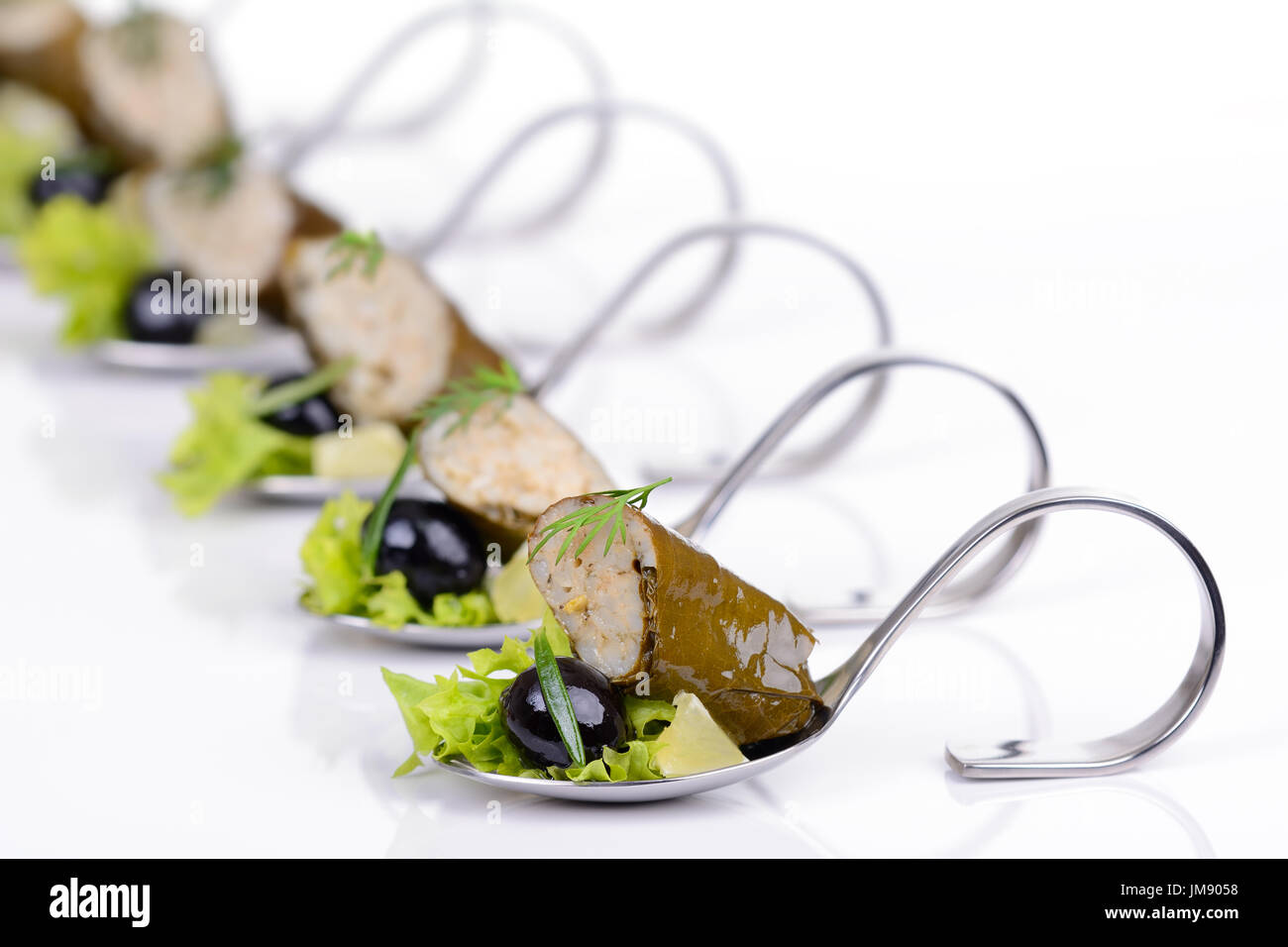 Stuffed grape leaves with black olives on appetizer spoons Stock Photo Alamy