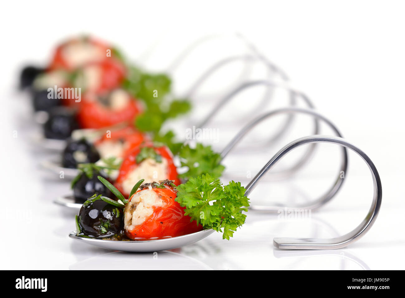 Stuffed hot cherry peppers, black olives and feta cheese on decorative