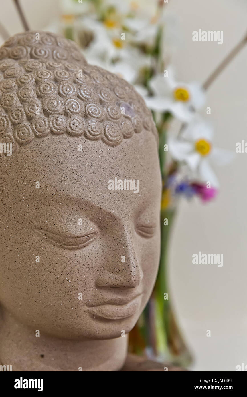 Buddha statue surrounded by vibrant color flowers Stock Photo - Alamy