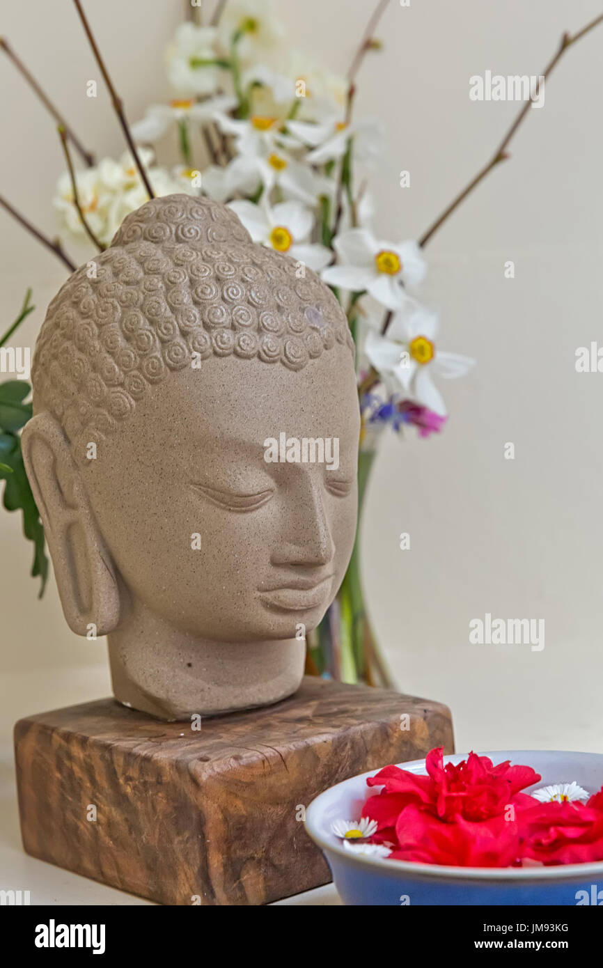 Buddha statue surrounded by vibrant color flowers Stock Photo - Alamy