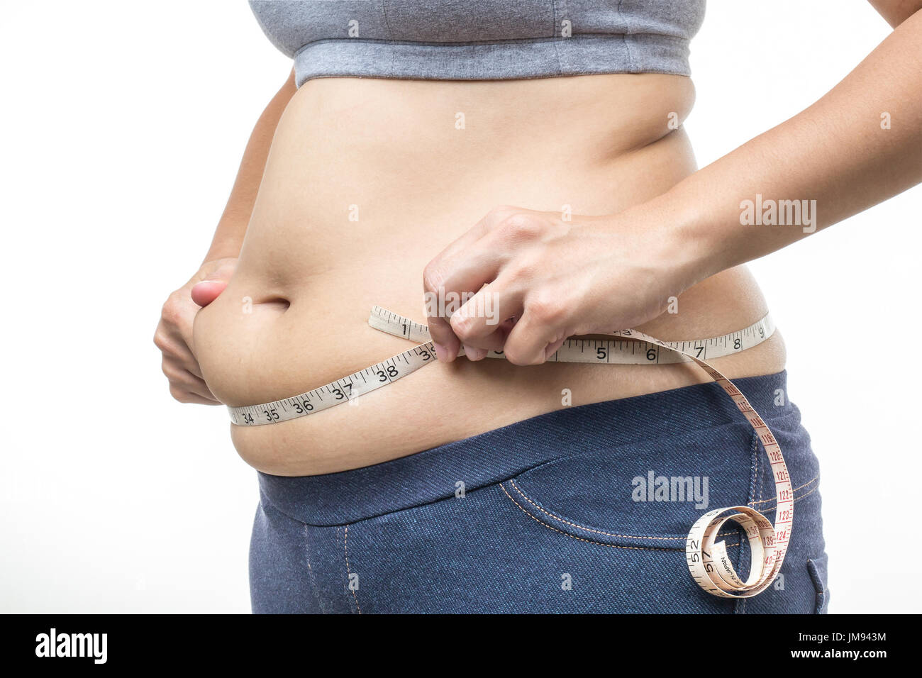 Overweight woman with tape measure around waist. Stock Photo by