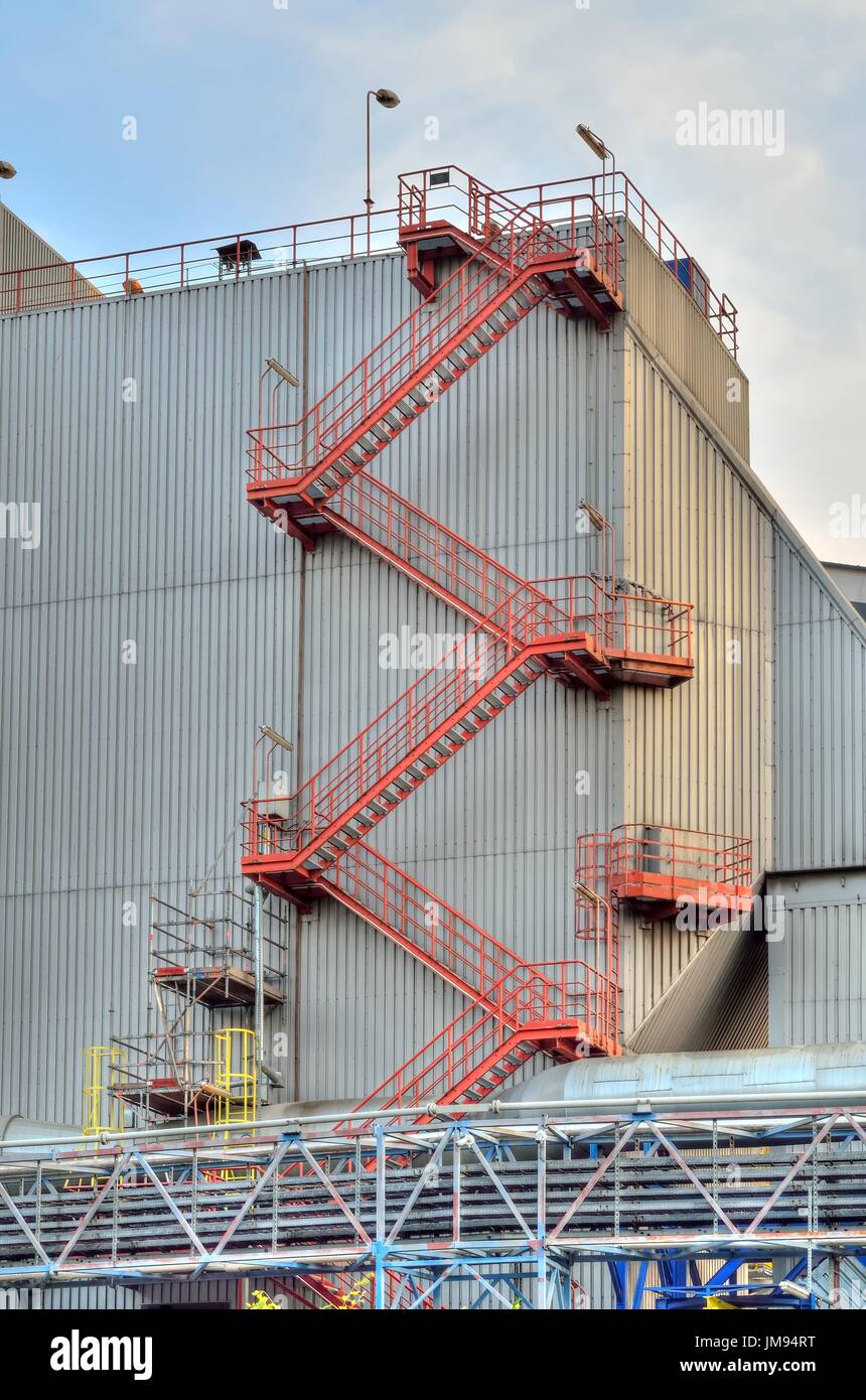Construction of a factory producing electricity. Emergency stairs on the factory wall. Stock Photo