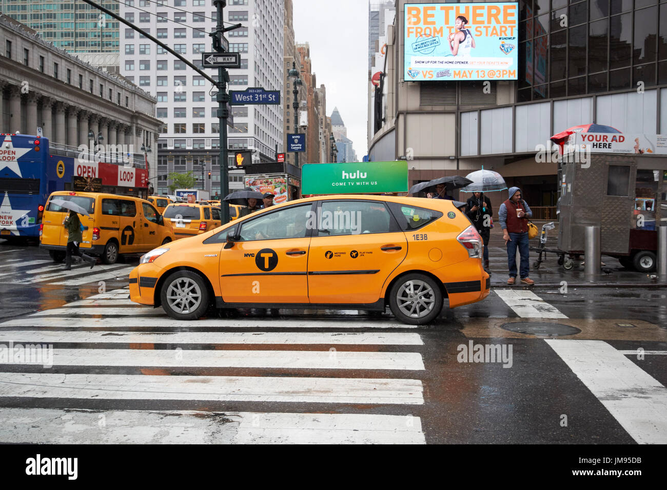 new york yellow taxi cab crossing crosswalk in the rain New York City USA Stock Photo