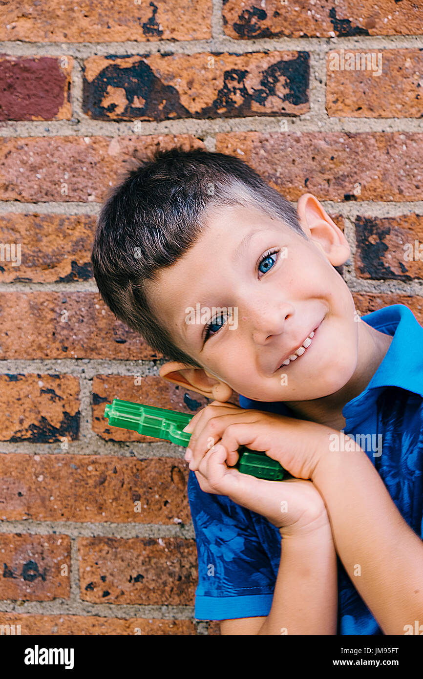 Portrait of kid on brown brick wall Stock Photo