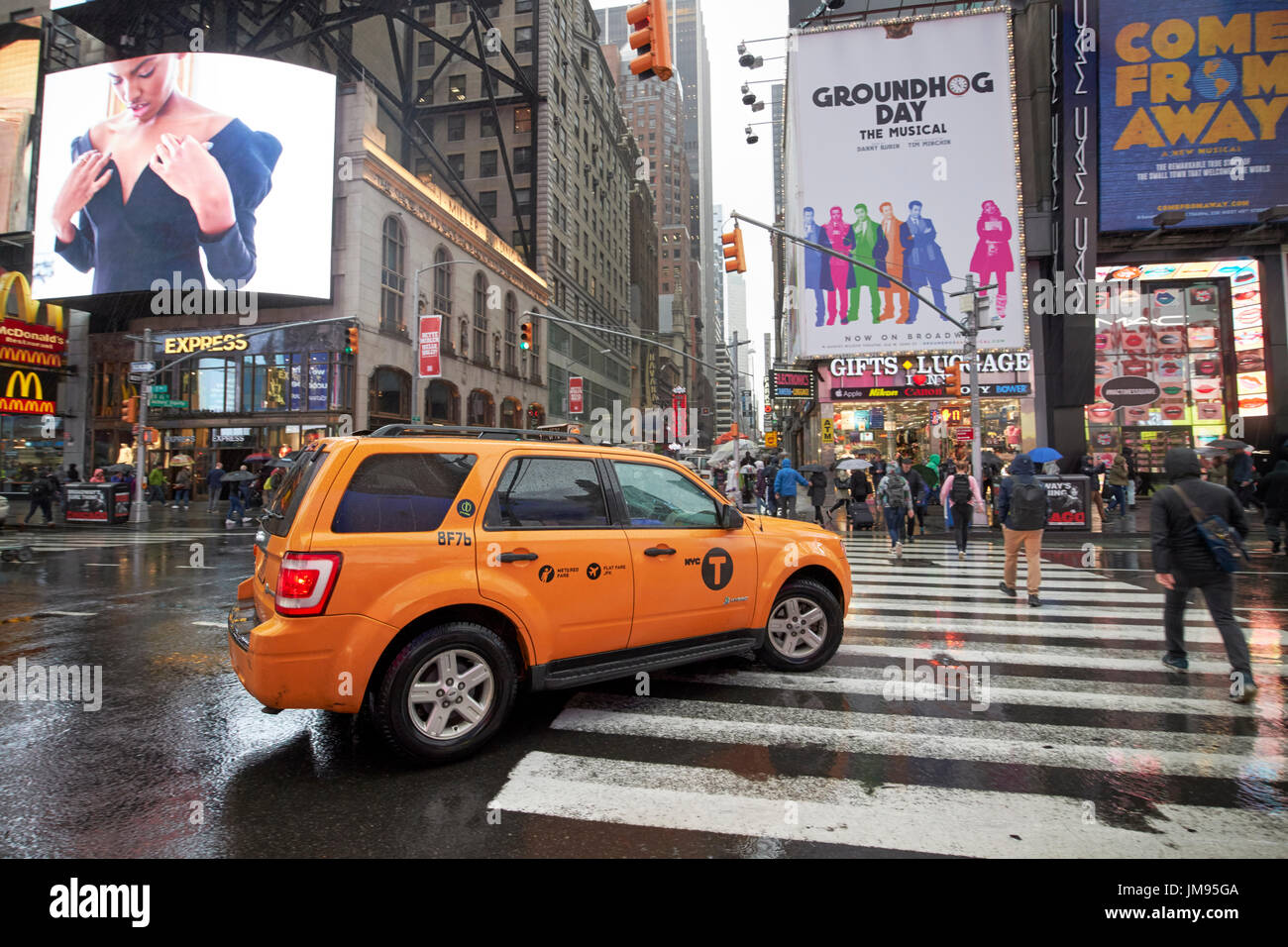 ford escape hybrid suv new york yellow taxi cab on crossing times square in the rain New York City USA Stock Photo