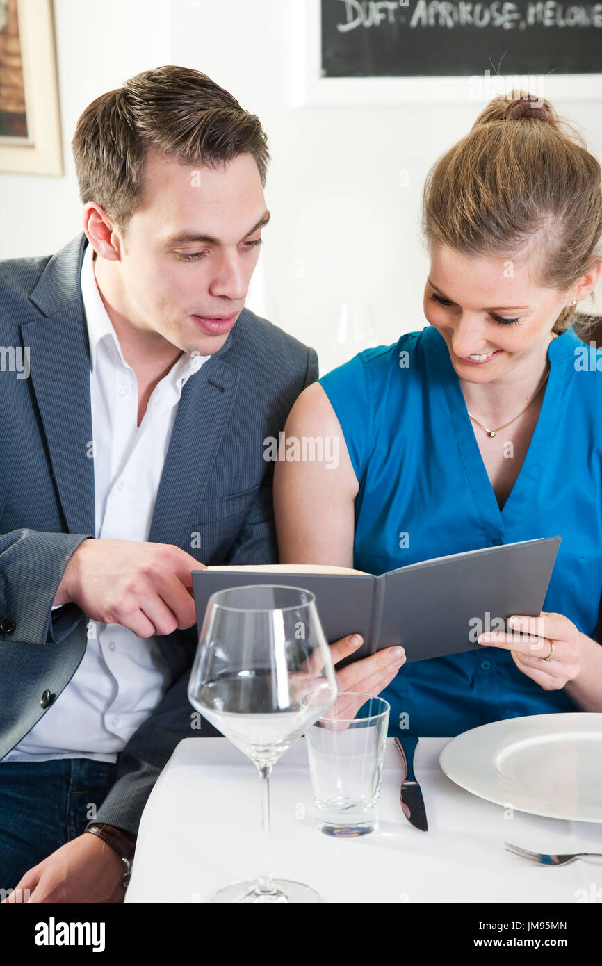 Couple is reading the menu together in a restaurant Stock Photo