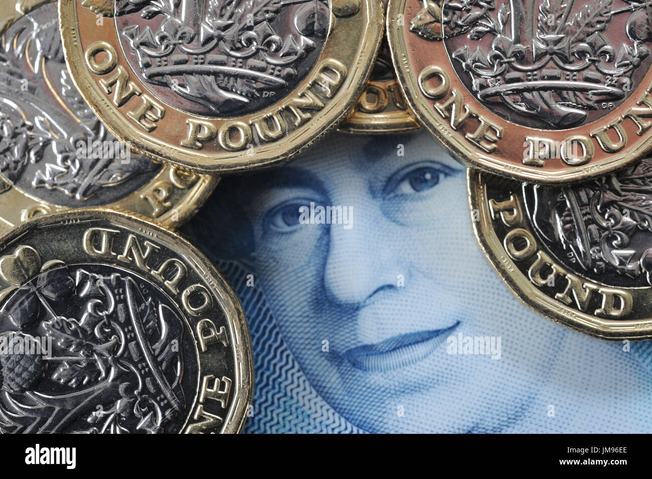 NEW ONE POUND COINS WITH QUEENS HEAD ON NEW FIVE POUND NOTE RE FINANCE BREXIT SAVERS SAVINGS HOUSEHOLD BUDGETS INFLATION INVESTMENTS MONEY WAGES UK Stock Photo
