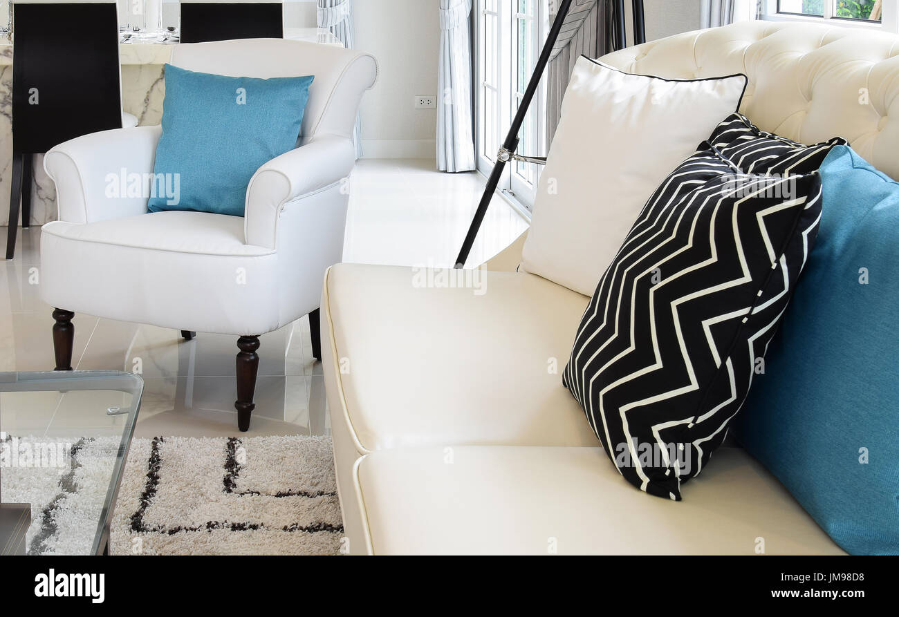 White And Blue Pillows On A White Leather Couch In Vintage Living