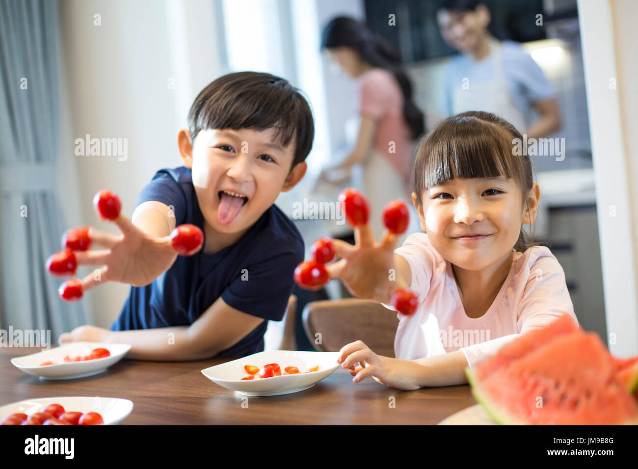 Happy Chinese siblings and cherry tomatoes Stock Photo Alamy