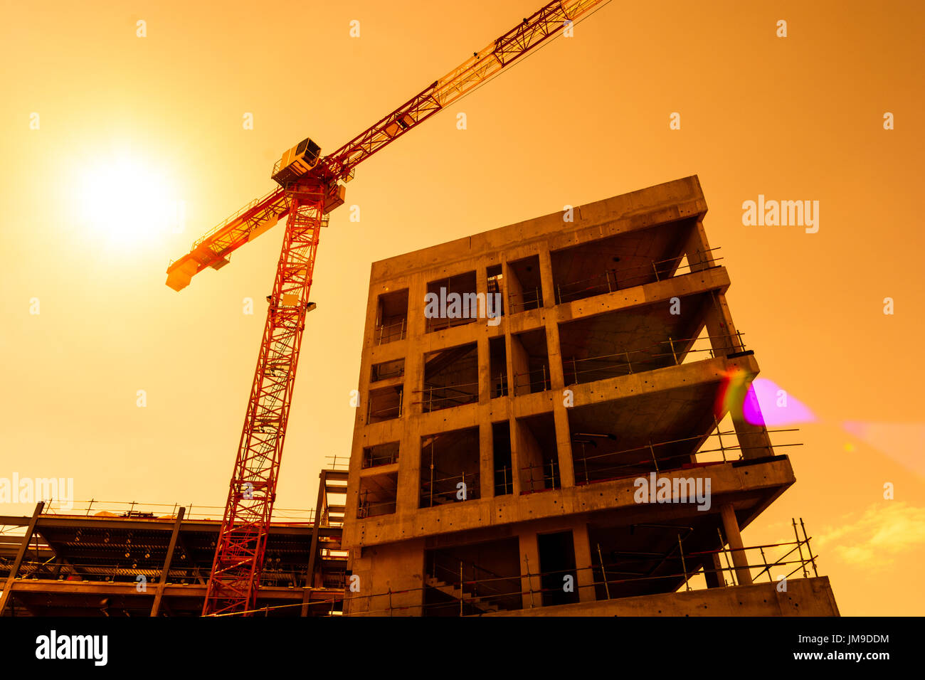 Low angle view of a tower crane next to a concrete building under ...