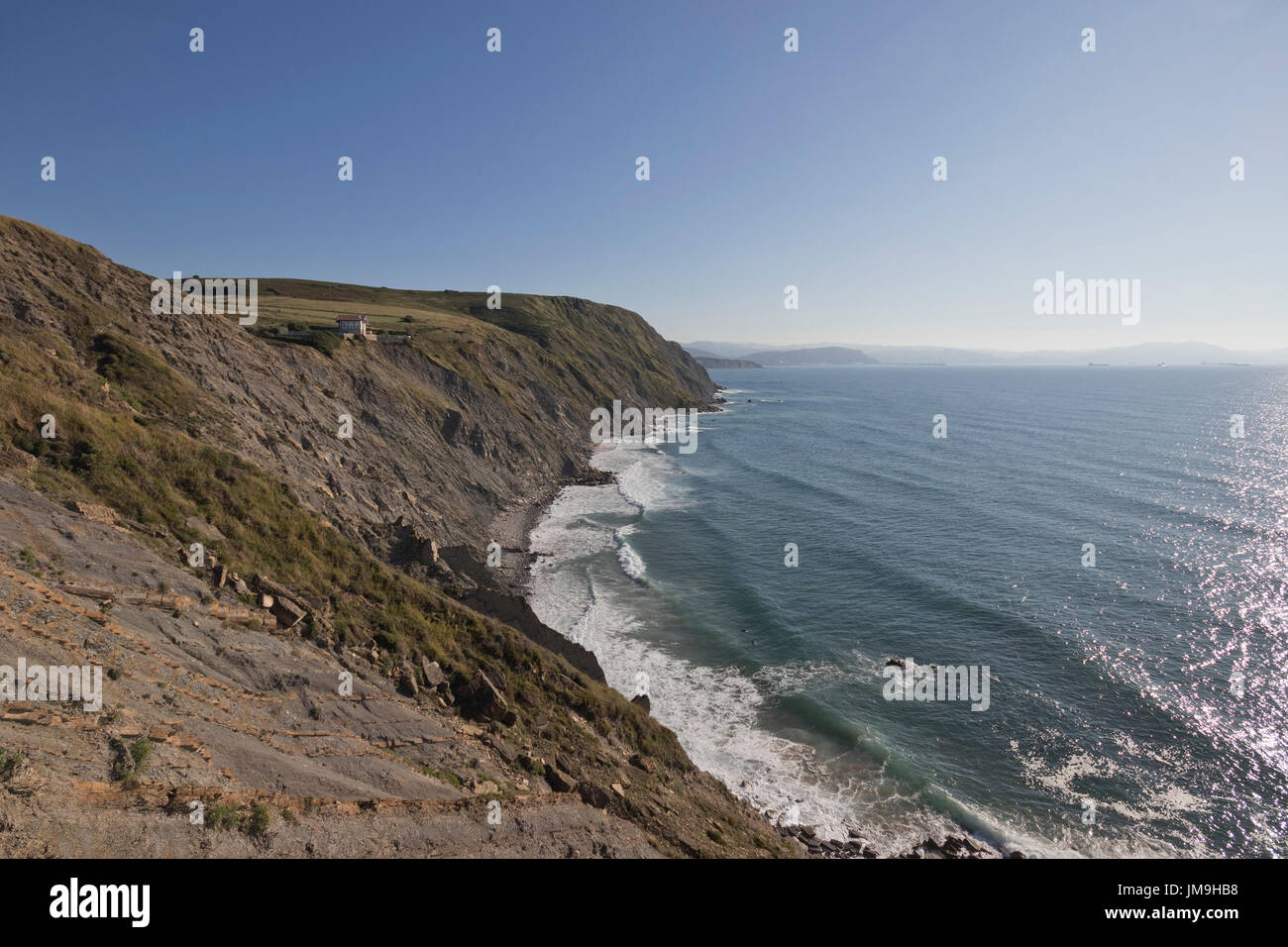 Wide angle view of Barrika cliff with a house at the edge (Bizkaia, Euskadi, Spain). Stock Photo