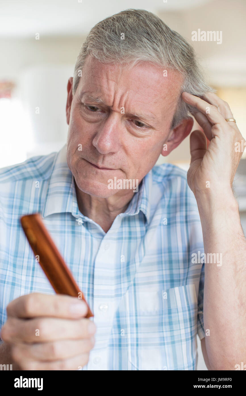 Senior Man With Comb Corncerned About Hair Loss Stock Photo