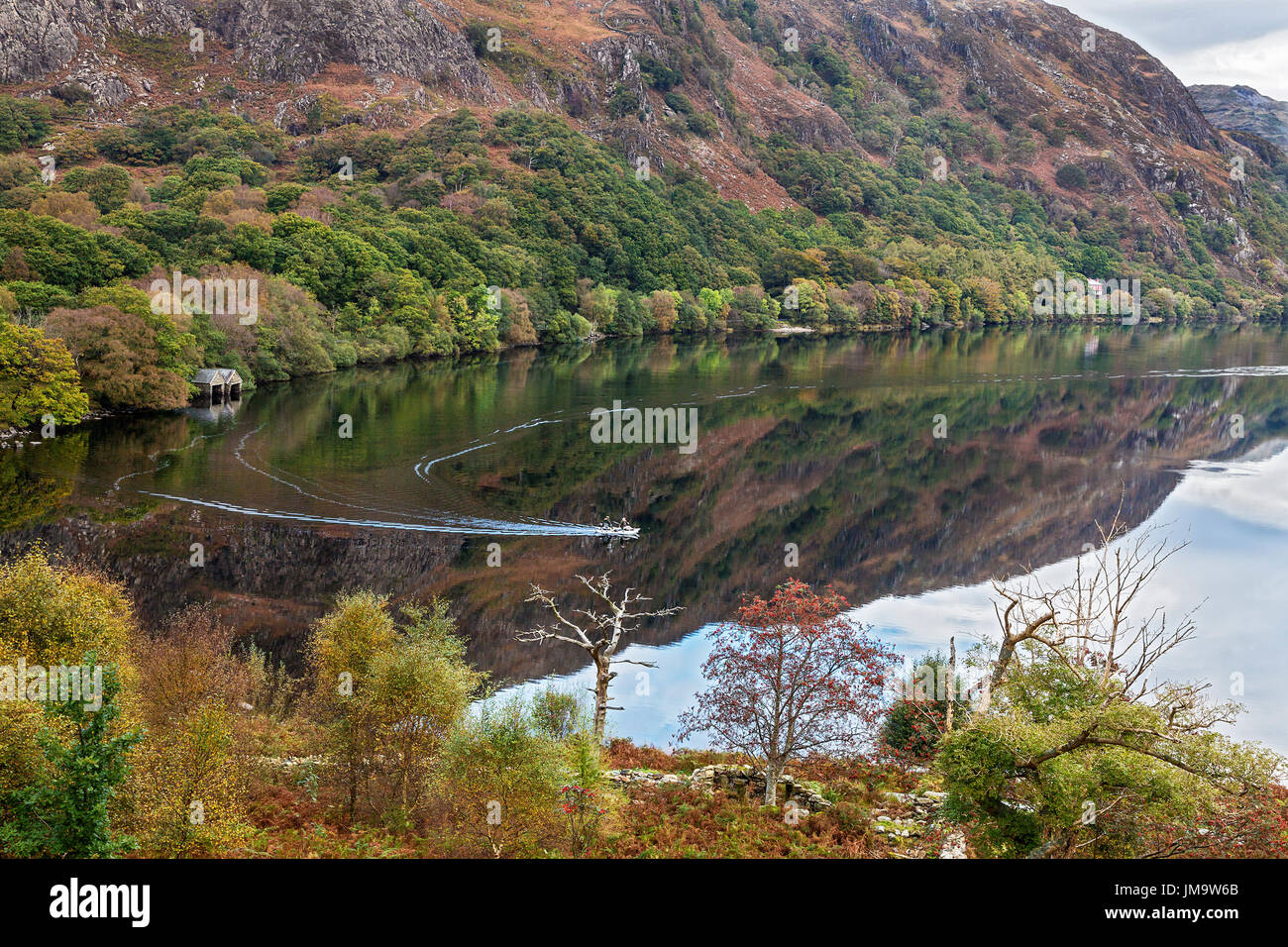 Reflections in Llyn Dinas with fishermen in a boat Nant Gwynant valley near Beddgelert Snowdonia National Park North Wales UK October 50500 Stock Photo