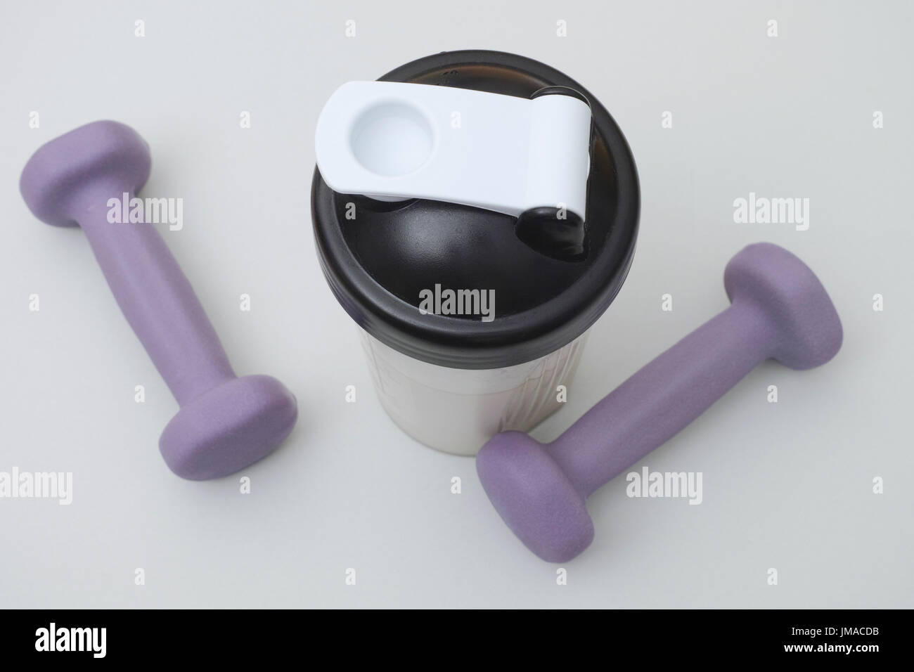 Protein shake and dumbbells. Close up. Stock Photo