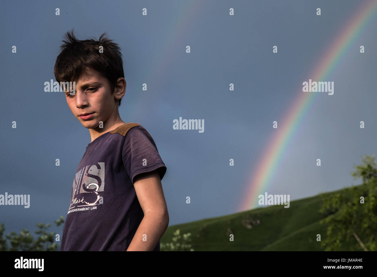 Chechnya, Russia. 25th July, 2017. A boy walks in front of a rainbow in Vedensky District, Chechnya, Russia, on July 25, 2017. Credit: Bai Xueqi/Xinhua/Alamy Live News Stock Photo