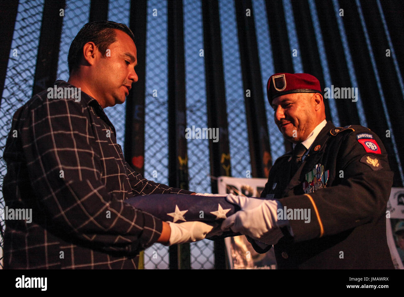 Tijuana, Baja California, Mexico. 4th July, 2017. EDWIN SALGADO (L), a deported U.S. Marine Corps veteran, and HECTOR BARAJAS-VARELA (R), a deported U.S. Army veteran, fold an American flag during a 4th of July celebration along the US-Mexico border in Tijuana, Baja California, Mexico. Credit: Joel Angel Juarez/ZUMA Wire/Alamy Live News Stock Photo