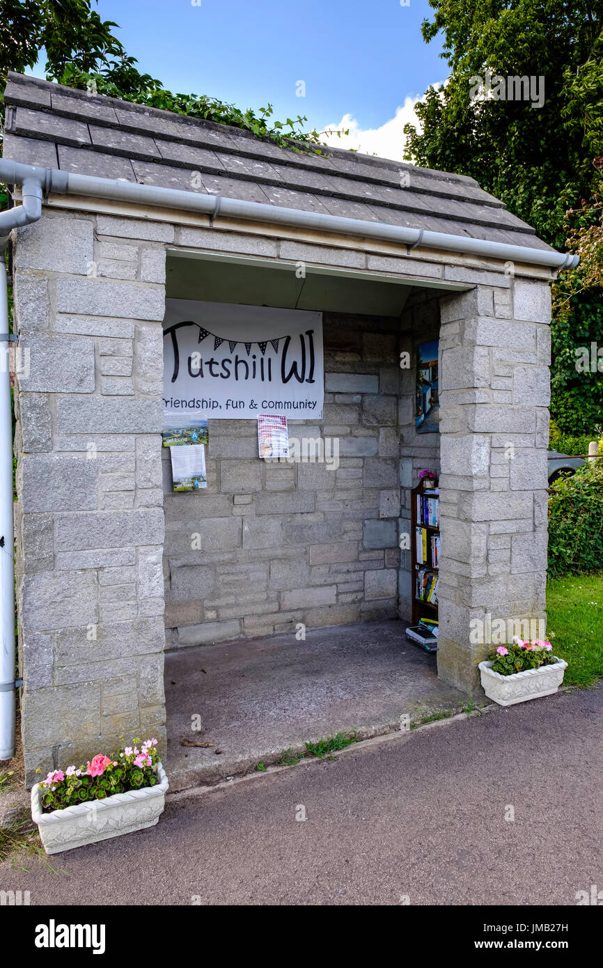 COMMUNITY BUS STOP IN NUTSHELL GLOUCESTERSHIRE IN CARE OF LOCAL WOMEN'S INSTITUTE WITH PLANTS AND LIBRARY BOOKS Stock Photo