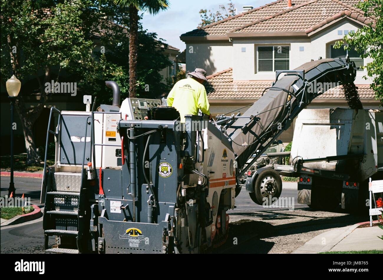 A construction worker for American Asphalt drives a large piece of construction equipment during a road construction and resurfacing project in the San Francisco Bay Area suburb of San Ramon, California, June 26, 2017. Stock Photo