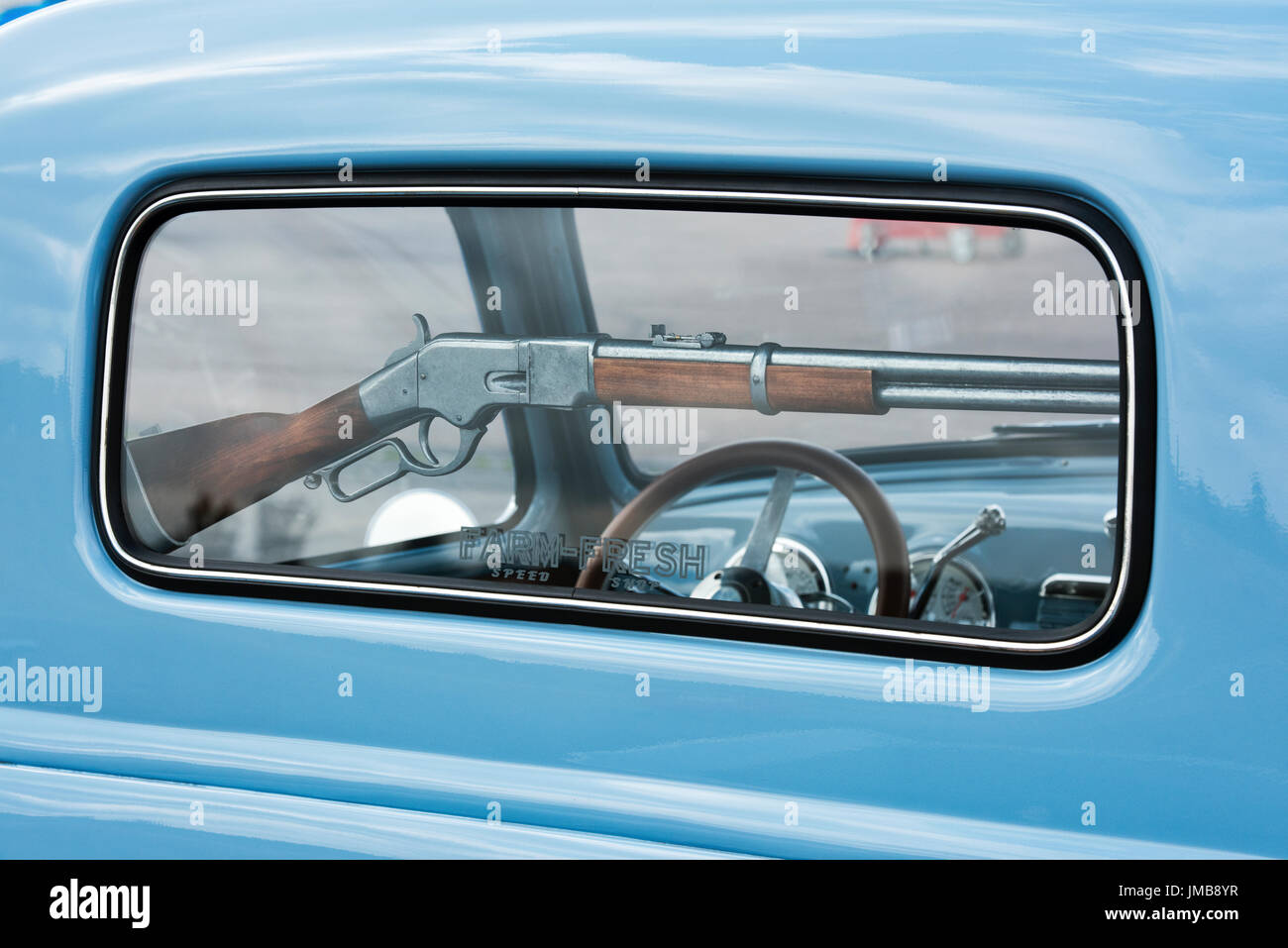 Replica winchester rifle in the rear window of a 1953 Custom Chevrolet pick up truck at an American car show. Essex. UK Stock Photo