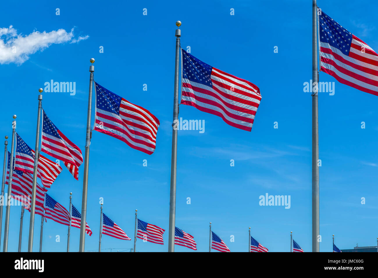 American flags on flag poles against a blue sky wave in the wind Stock ...