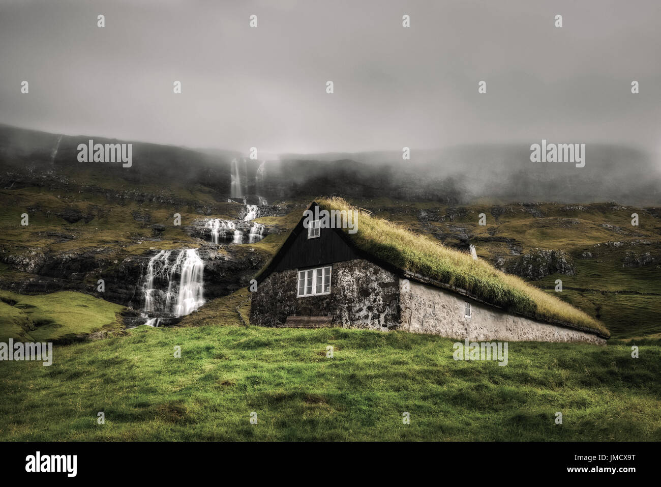 Historic stone house with turf roof on the island of Streymoy, Saksun, Faroe Islands. Vintage style color tone processed. Stock Photo