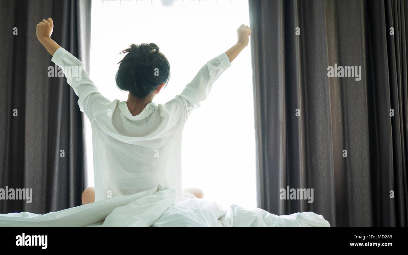 Asian women wake up from sleep. are stretch herself in the morning on ...