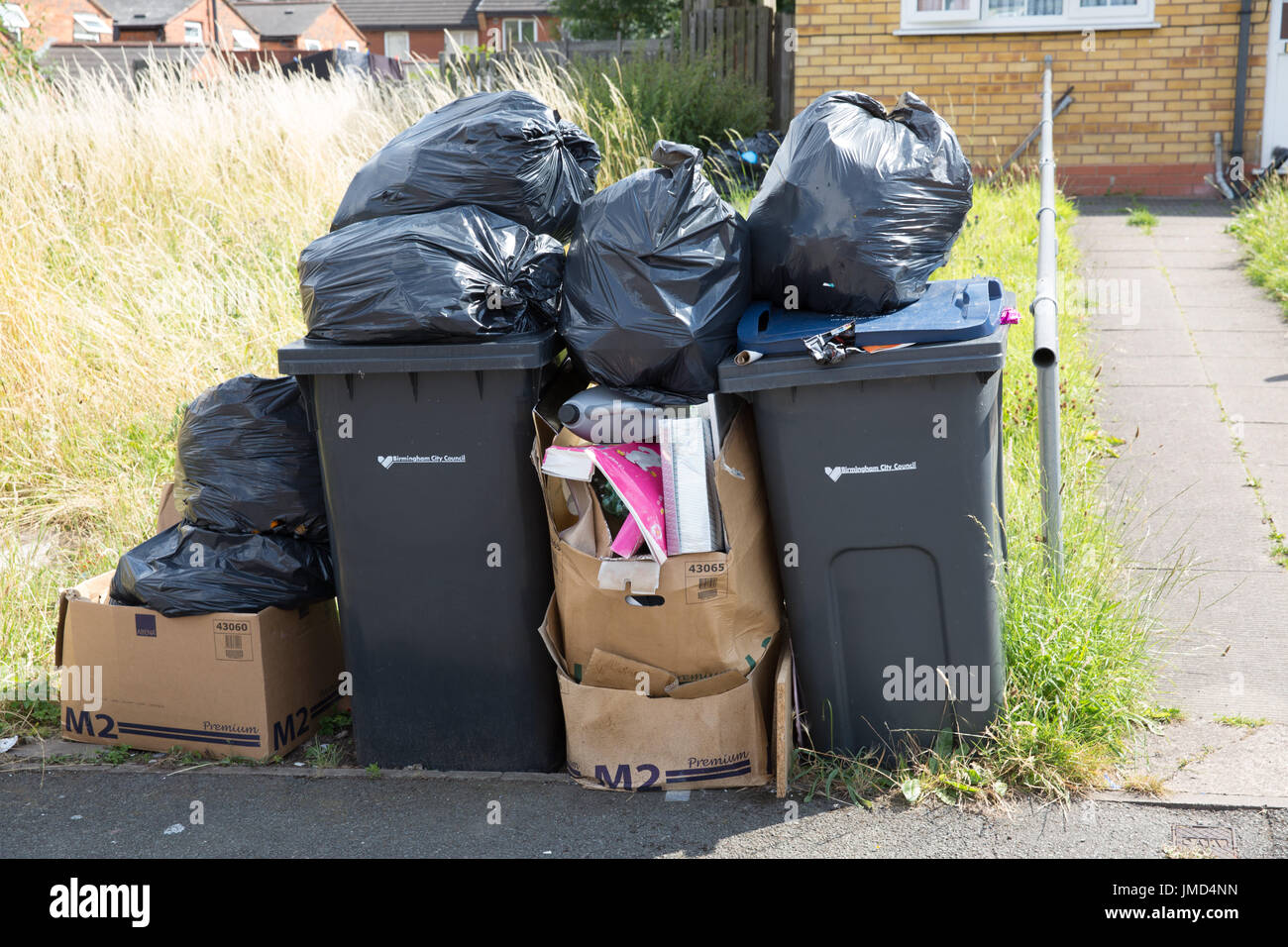 Piles of uncollected rubbish in Kimberley Avenue, Alum Rock, Birmingham. The refuse collectors are on strike protesting against staff cuts. Stock Photo